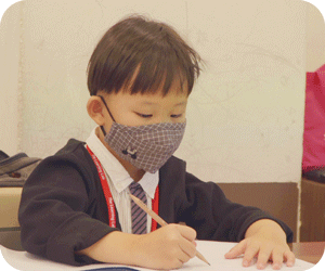 A kindergarten 2 (K2) student focusing on an assignment during tuition class at The Learning Lab