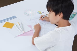 Primary student at The Learning Lab solving problems on worksheet